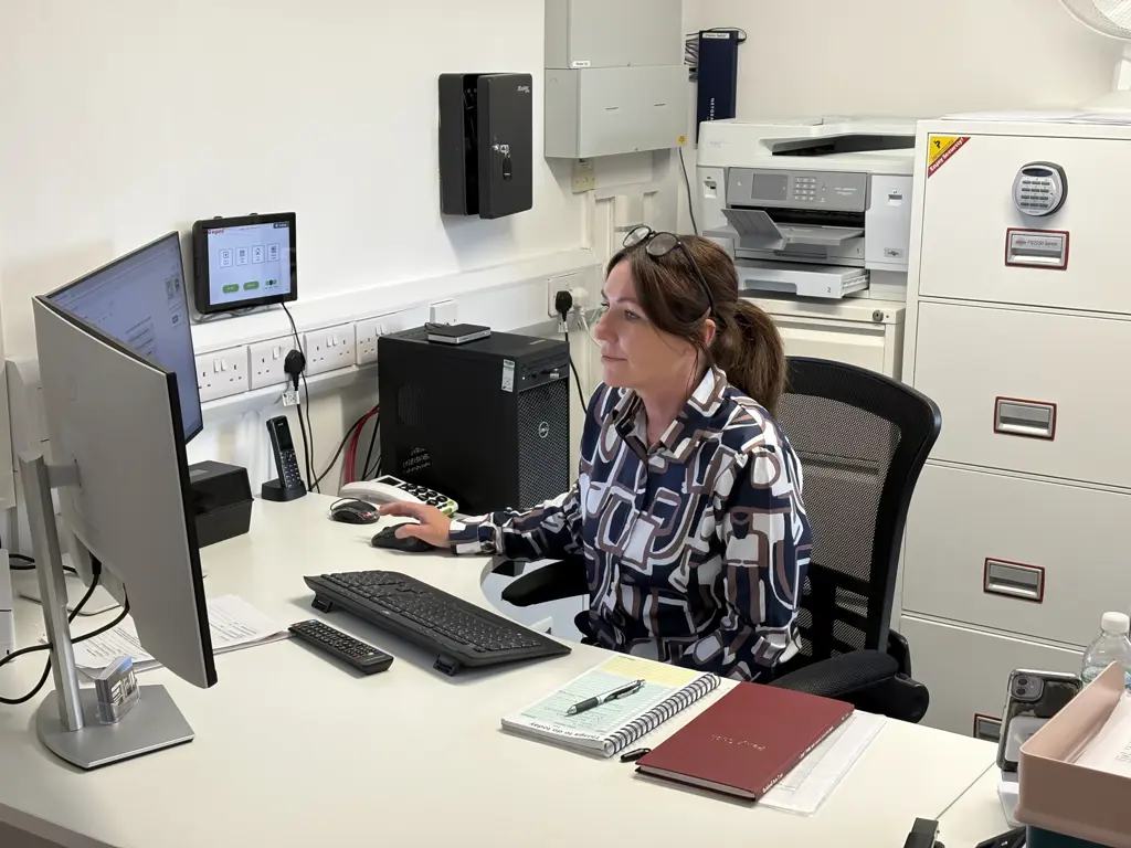 Keenan, Scheme Manager (Reading Court) at work in a busy management office at Reading Court.