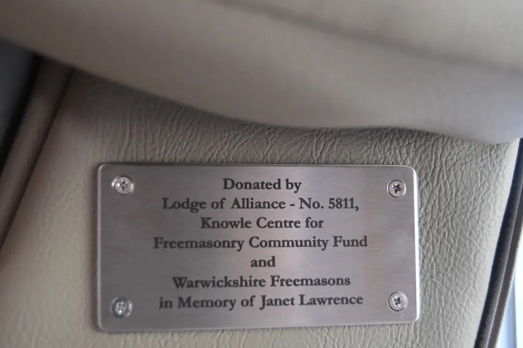 The plaque attached to the therapy chair commemorates its donation in memory of Janet Lawrence. Alt text: Memorial plaque on the therapy chair donated in memory of Janet Lawrence.